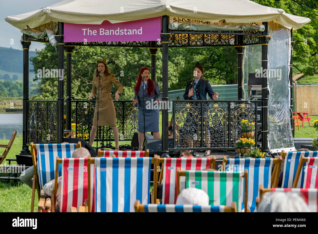 Dans l'auditoire transats regarder la musique interprétée sur kiosque par groupe de 3 chanteuses (trio) - RHS Flower Show de Chatsworth, Derbyshire, Angleterre, Royaume-Uni. Banque D'Images