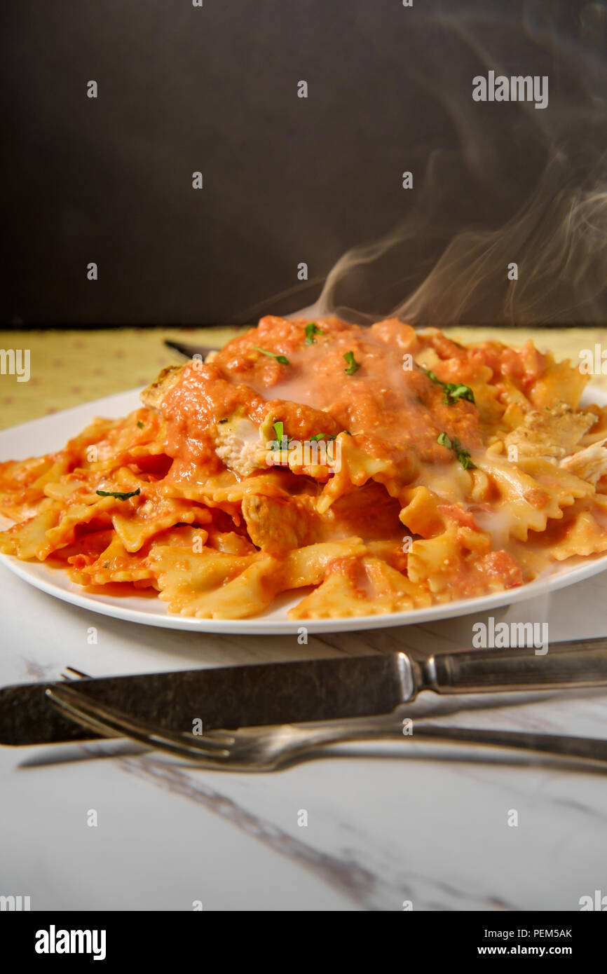 Pâtes Farfalle Bow tie dans la vodka crème de poulet grillé sauce tomate et petits pois Banque D'Images