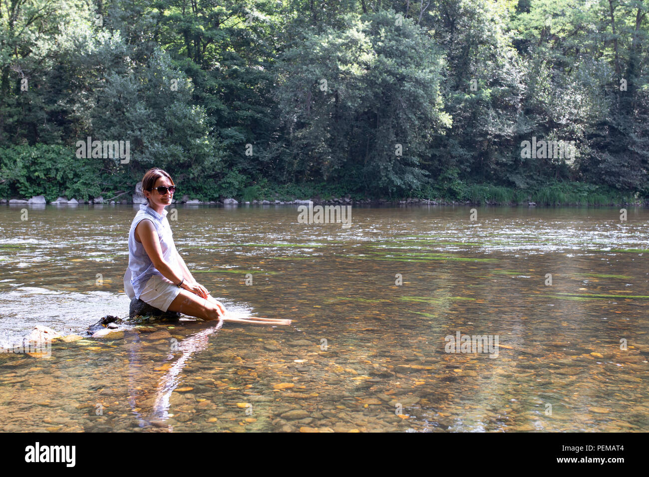Belle femme ses jambes de refroidissement dans une rivière, l'onde de Chaleur, chaleur de l'été, en France. Banque D'Images