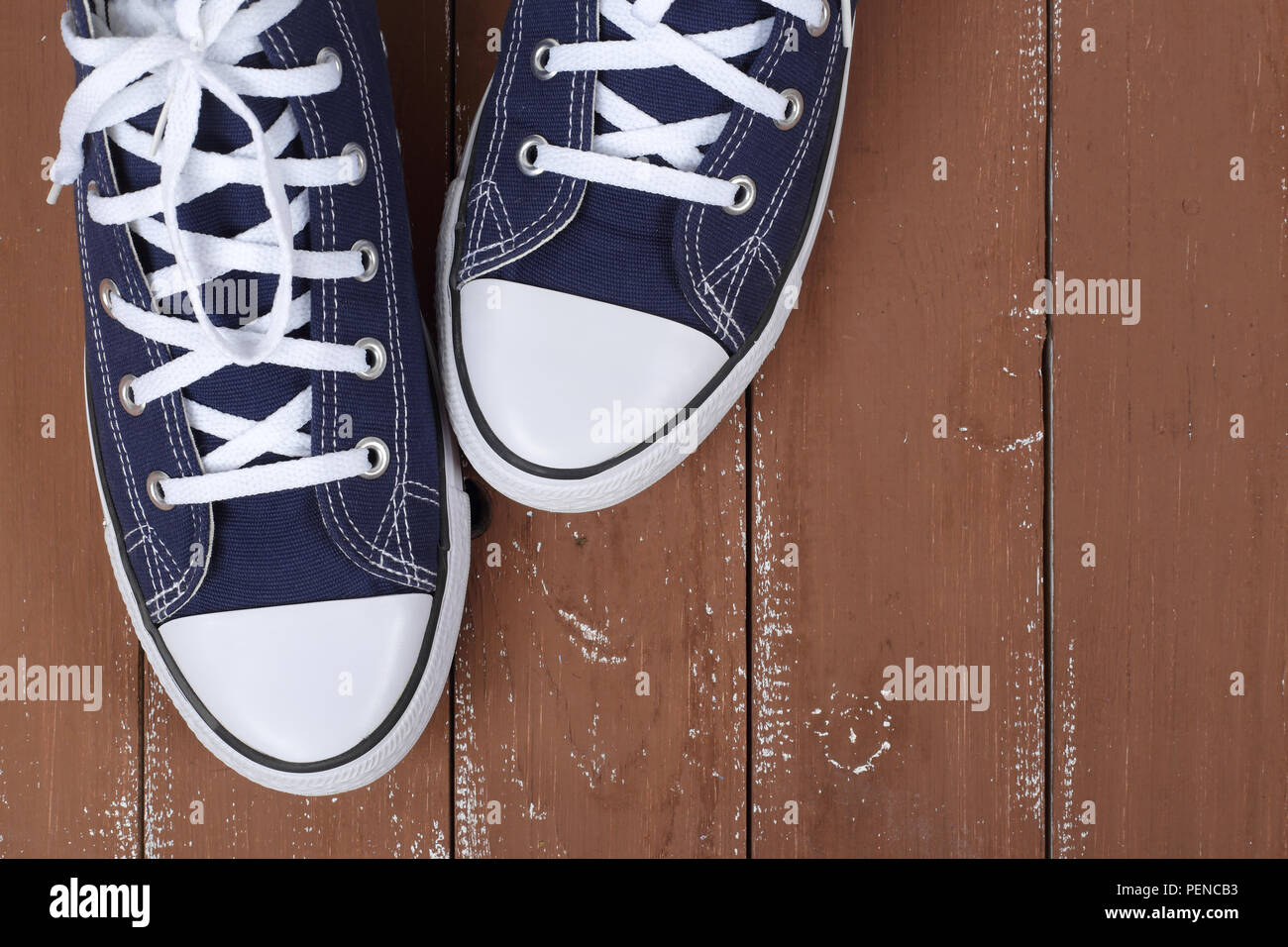 Vêtements, chaussures et accessoires - Vue de dessus gros plan du fragment bleu paire gumshoes on a wooden background Banque D'Images