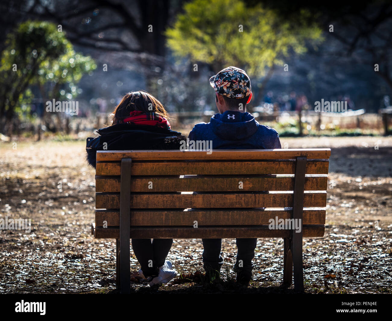 Vie du parc Tokyo Yoyogi Park - un couple se détendre sur un banc de parc en Parc Yoyogi à Shibuya-ku Tokyo JAPON Banque D'Images