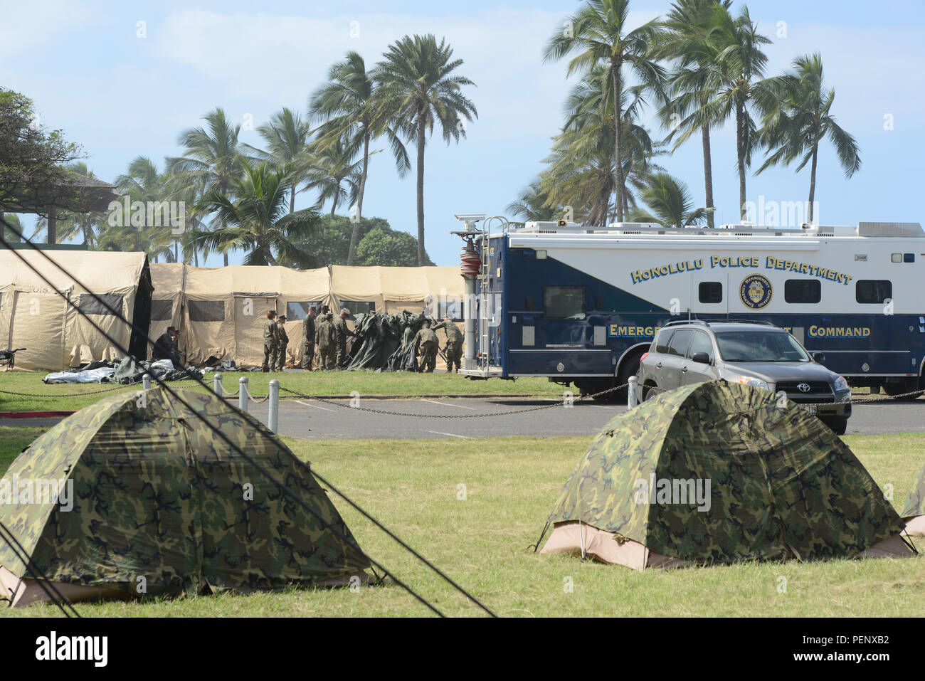 Membres de l'équipage du Marine Corps mis en place des tentes et du matériel de la Haleiwa Beach Park poste de commandement pour aider à la recherche d'efforts 12 aviateurs marins au large de la côte nord d'Oahu, 16 janvier 2016. La Garde côtière canadienne et plusieurs organismes partenaires sont la poursuite de la recherche après l'avis de deux hélicoptères militaires abattus, chacun aurait été avec six membres du personnel à bord, 14 janvier 2016. (U.S. Photo de la Garde côtière du Maître de 2e classe Tara Molle/libérés) Banque D'Images