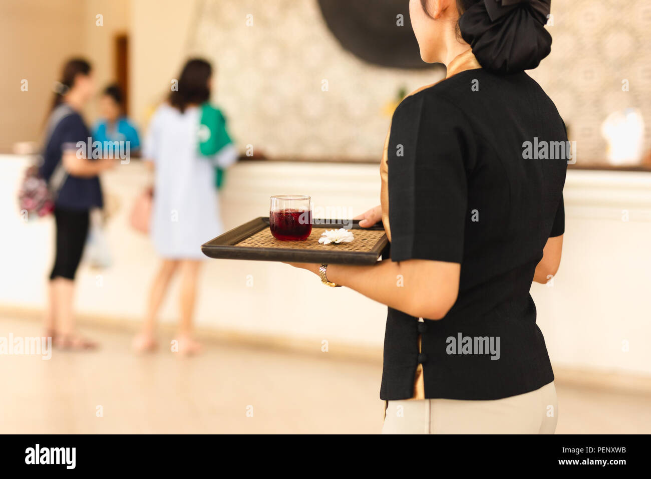 Serveuse avec boisson de bienvenue sur un plateau à la réception de l'hôtel. Banque D'Images