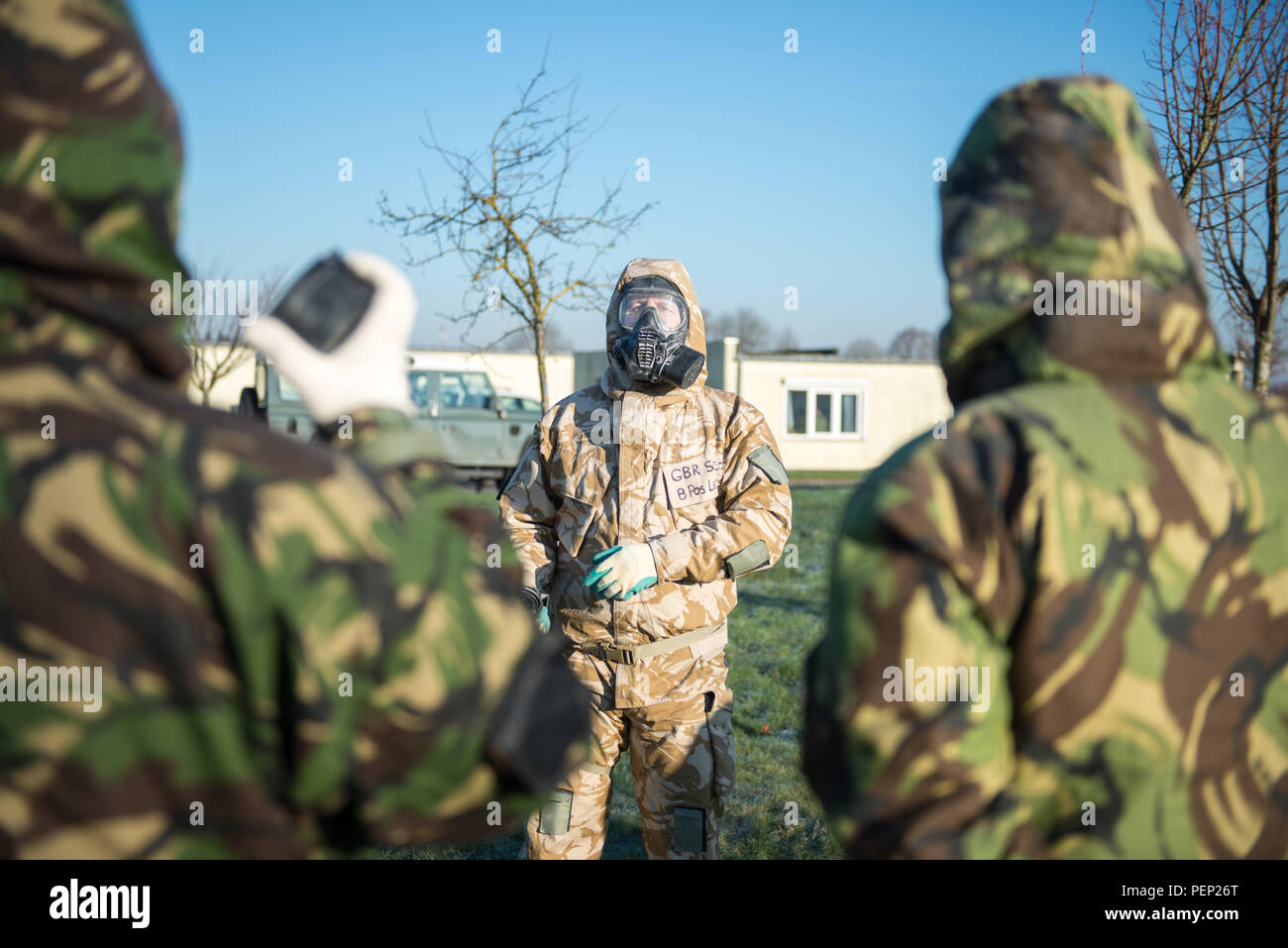 Un sous-officier, centre, avec l'équipe de formation européenne conjointe montre les membres de l'organisation des forces armées britanniques, affectés à des unités locales, comment remplacer les filtres de leur respirateur Services généraux avant d'entrer dans le centre d'appui à la formation de l'armée américaine Bureau Benelux des armes chimiques, biologiques, radiologiques et nucléaires de détente sur la base aérienne de Chièvres, Belgique, le 19 janvier 2016. (U.S. Photo de l'armée par Visual Spécialiste de l'information, Pierre-Etienne Courtejoie / relâché) Banque D'Images