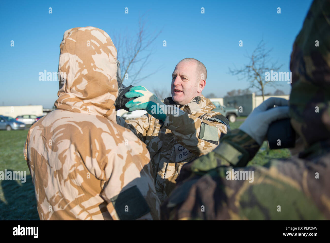 Un sous-officier, avec l'équipe de formation européens communs, ajuste l'un des filtres d'un service général de ce rythme portés par un membre des forces armées britanniques, affecté à une unité locale, avant d'entrer dans le centre d'appui à la formation de l'armée américaine Bureau Benelux des armes chimiques, biologiques, radiologiques et nucléaires de détente sur la base aérienne de Chièvres, Belgique, le 19 janvier 2016. (U.S. Photo de l'armée par Visual Spécialiste de l'information, Pierre-Etienne Courtejoie / relâché) Banque D'Images