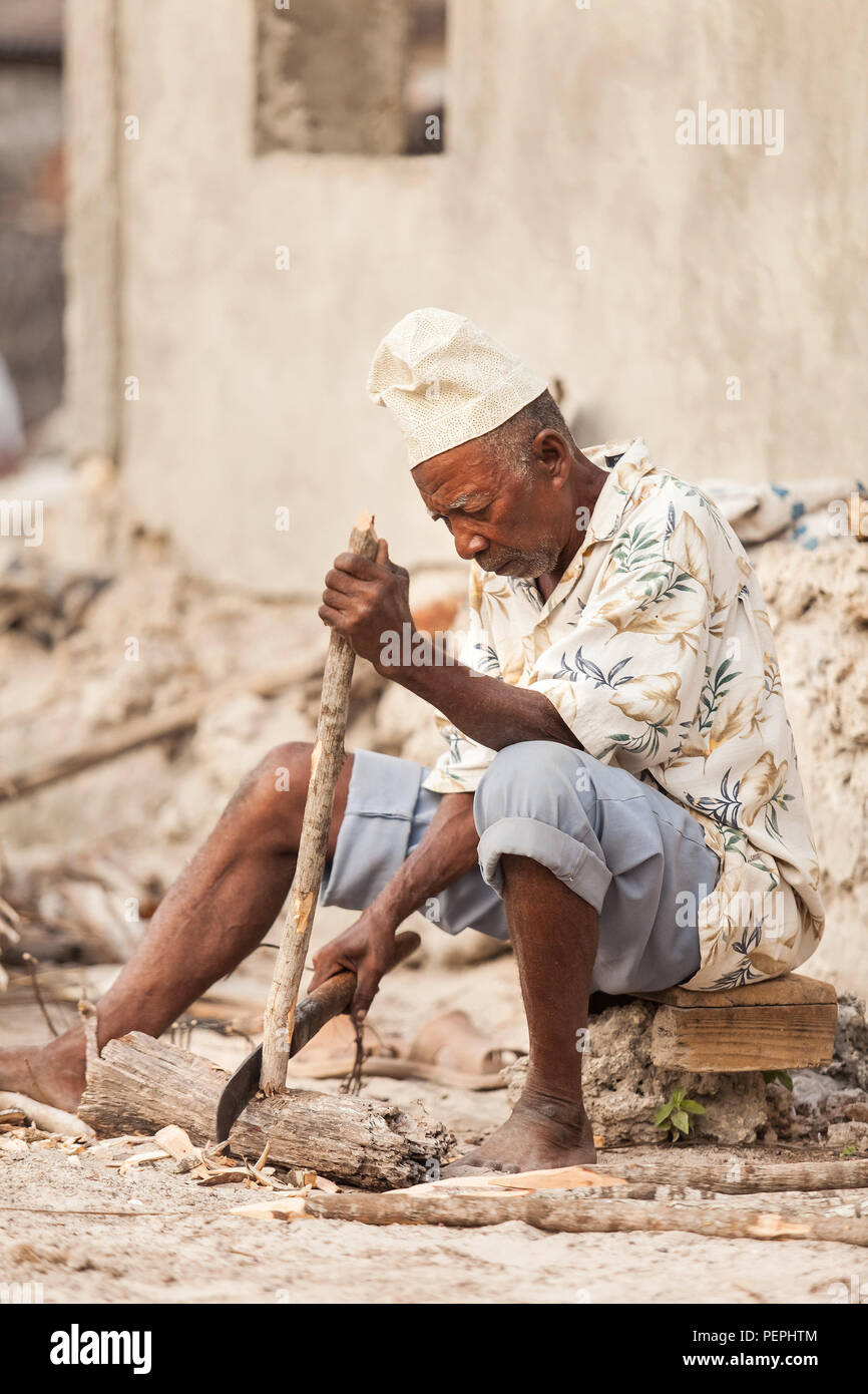 Stone Town, Zanzibar, 17 Janvier - 2015 : Man chopping wood avec grand couteau. Banque D'Images