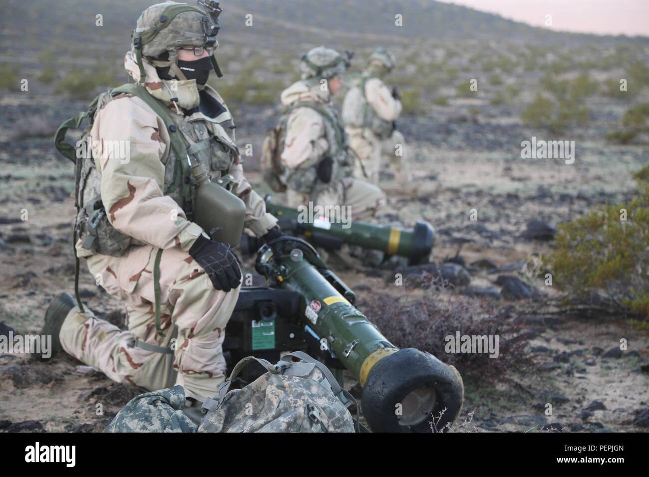 La FPC. David Chirco, affecté à la 3e Peloton, la Compagnie Alpha, 2e Bataillon, 1e Régiment d'infanterie, se cache derrière la dissimulation et renvoie le feu lors d'une action décisive 16-03 Rotation au Centre National d'entraînement ici, le 20 janvier 2016. Cette période de formation de 15 jours est d'assurer une approche plus globale pour les soldats au sein de la 2e brigade Stryker, l'équipe de combat 2e Division d'infanterie. (U.S. Photo de l'armée par le Sgt. Christopher Blanton, Operations Group, National Training Center) Banque D'Images