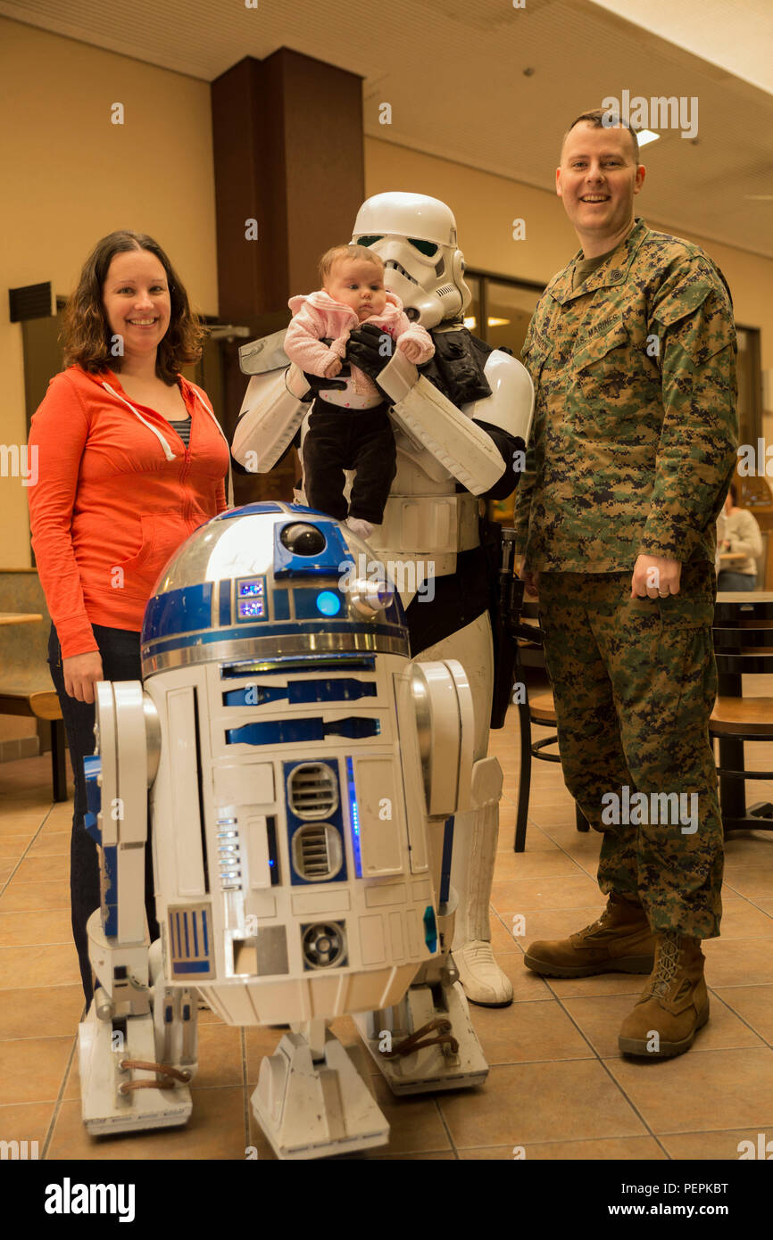 Le sergent d'artillerie. Clinton Firstbrook, station manager à l'Armed Forces Network, sa femme et sa fille Kara Evelyn posent pour une photo avec R2-D2 et un stormtrooper au carrefour Mall lors d'une promotion pour 'Star Wars : The Force éveille' au Marine Corps Air Station Iwakuni, Japon, le 15 janvier 2016. Richard Inoue, vêtu comme le stormtrooper a passé quatre ans à construire sa main R2-D2 replica connu comme R2-J1 et n'est officiellement autorisée. La promotion de la station fournie aux résidents l'occasion d'interagir et de prendre des photos de groupe avec les deux personnages. (U.S. Marine Corps photo par Lance Cpl. Aaron Henson/libérés) Banque D'Images