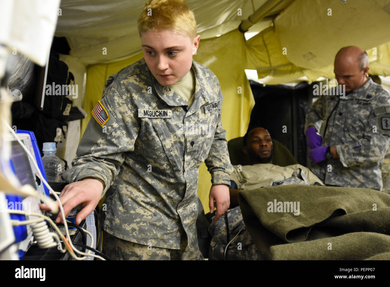 La CPS. Charlotte McGuckin, 212e de l'Hôpital de Soutien au Combat medic, vérifie les signes vitaux sur un rôle player casualty dans le traitement médical d'urgence tente au cours de 30e brigade médicale à l'exercice de l'MEDSHOCK Finthen LTA, Allemagne, le 27 janvier 2016. Comme ces exercices permettent de tester l'interopérabilité médicale entre l'OTAN a établi un partenariat des nations unies. (U.S. Photo de l'armée par le capitaine Jeku Arce, 30e brigade médicale parution/Affaires publiques) Banque D'Images