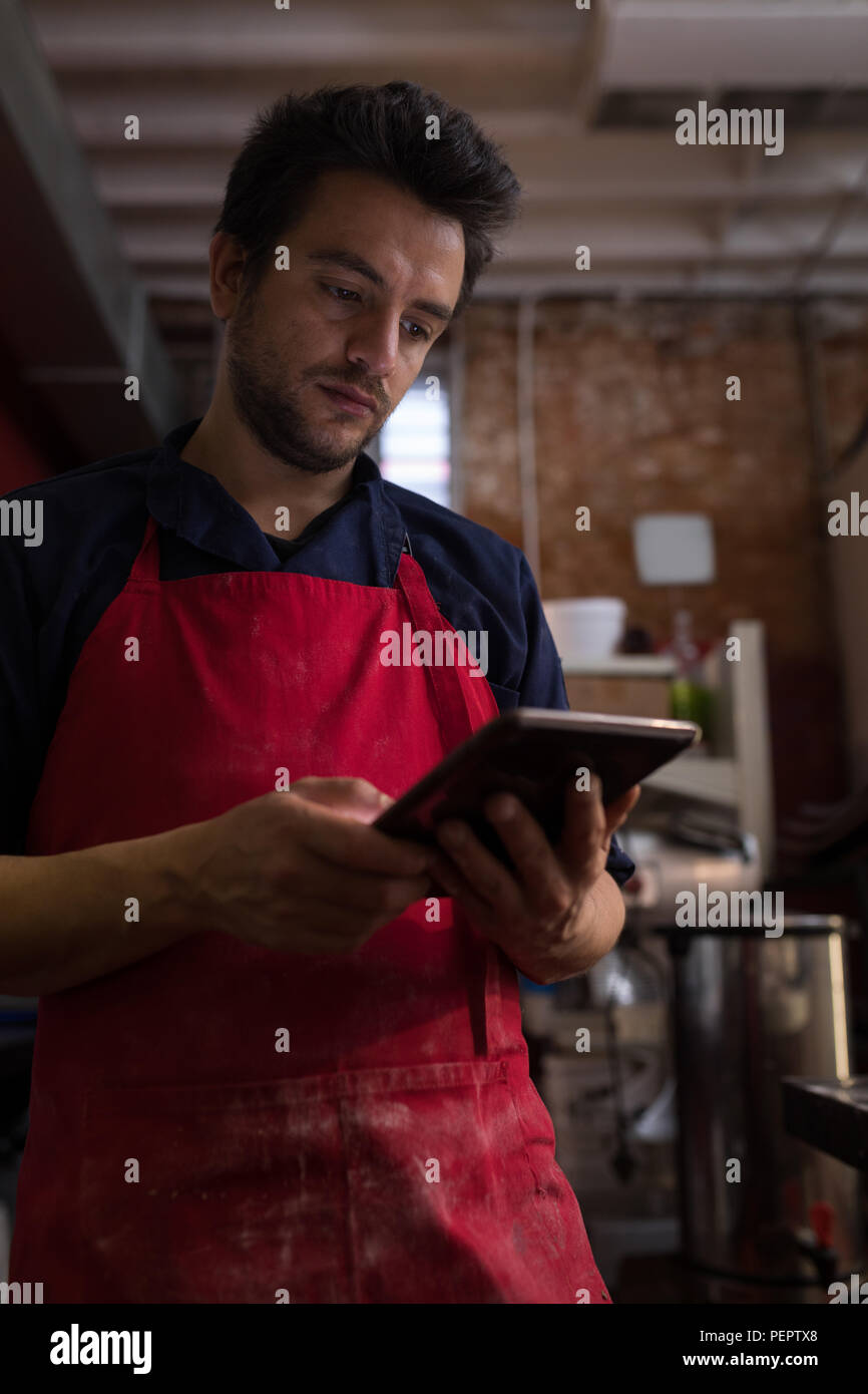 Male baker using digital tablet Banque D'Images Male baker using digital tablet Banque D'Images