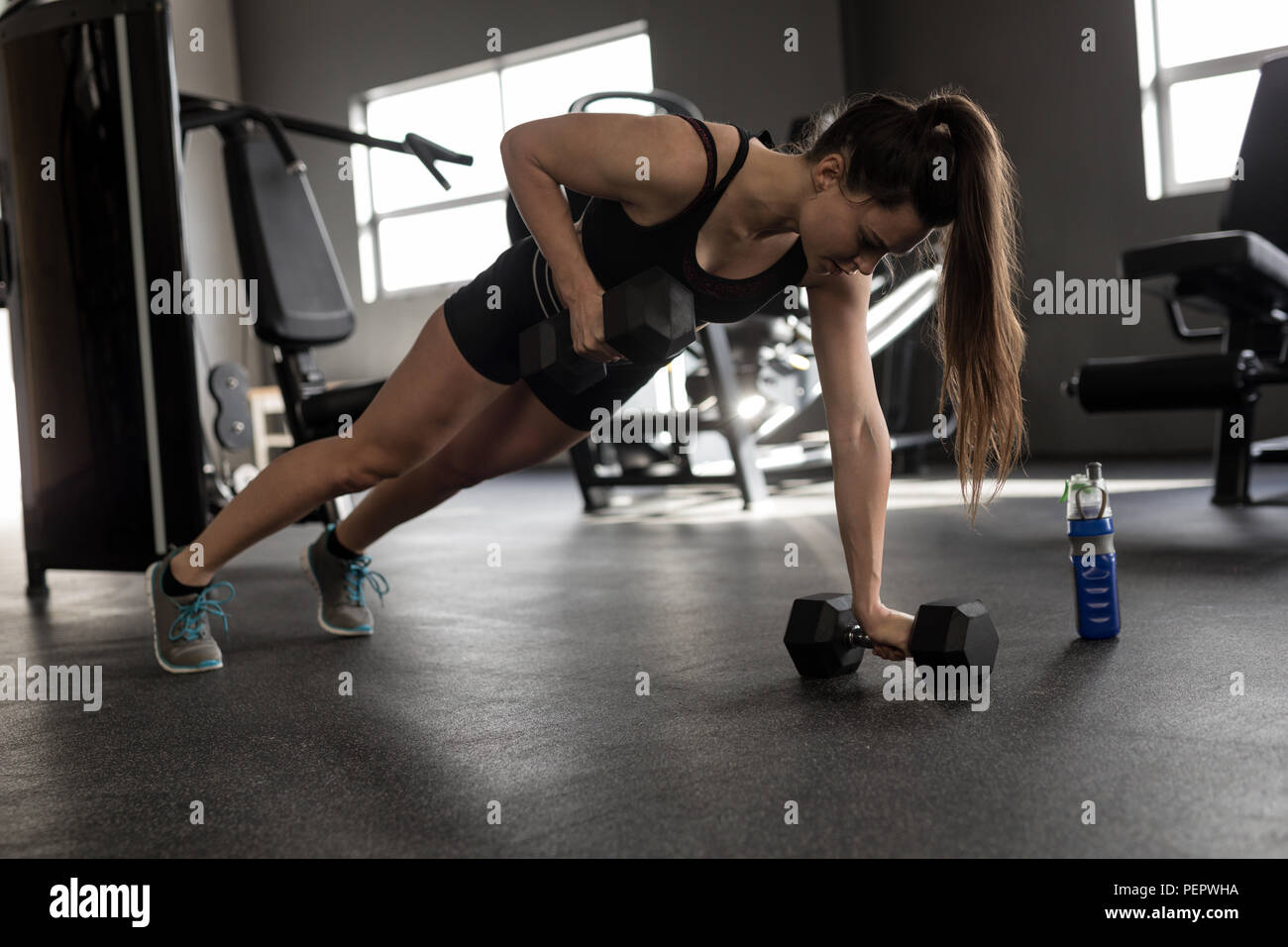 Femme poussez se lève sur les haltères in fitness studio Banque D'Images Femme poussez se lève sur les haltères in fitness studio Banque D'Images