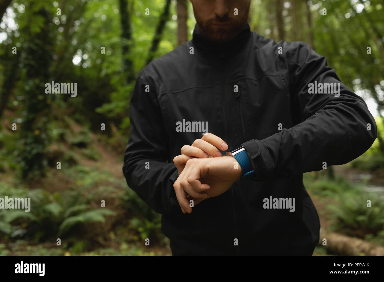 L'homme à l'aide de smart watch in forest Banque D'Images