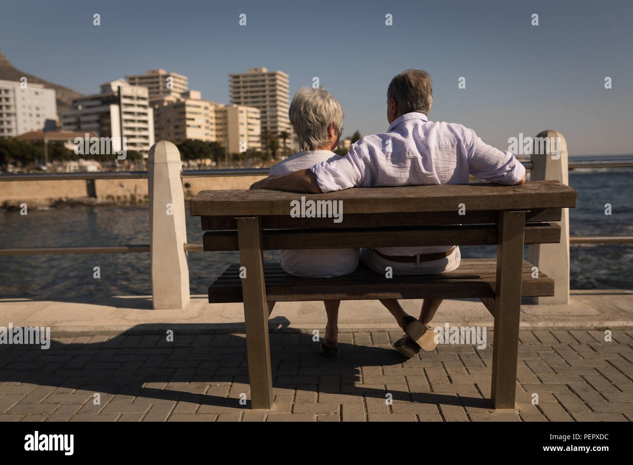 Couple assis sur un banc à la promenade Banque D'Images