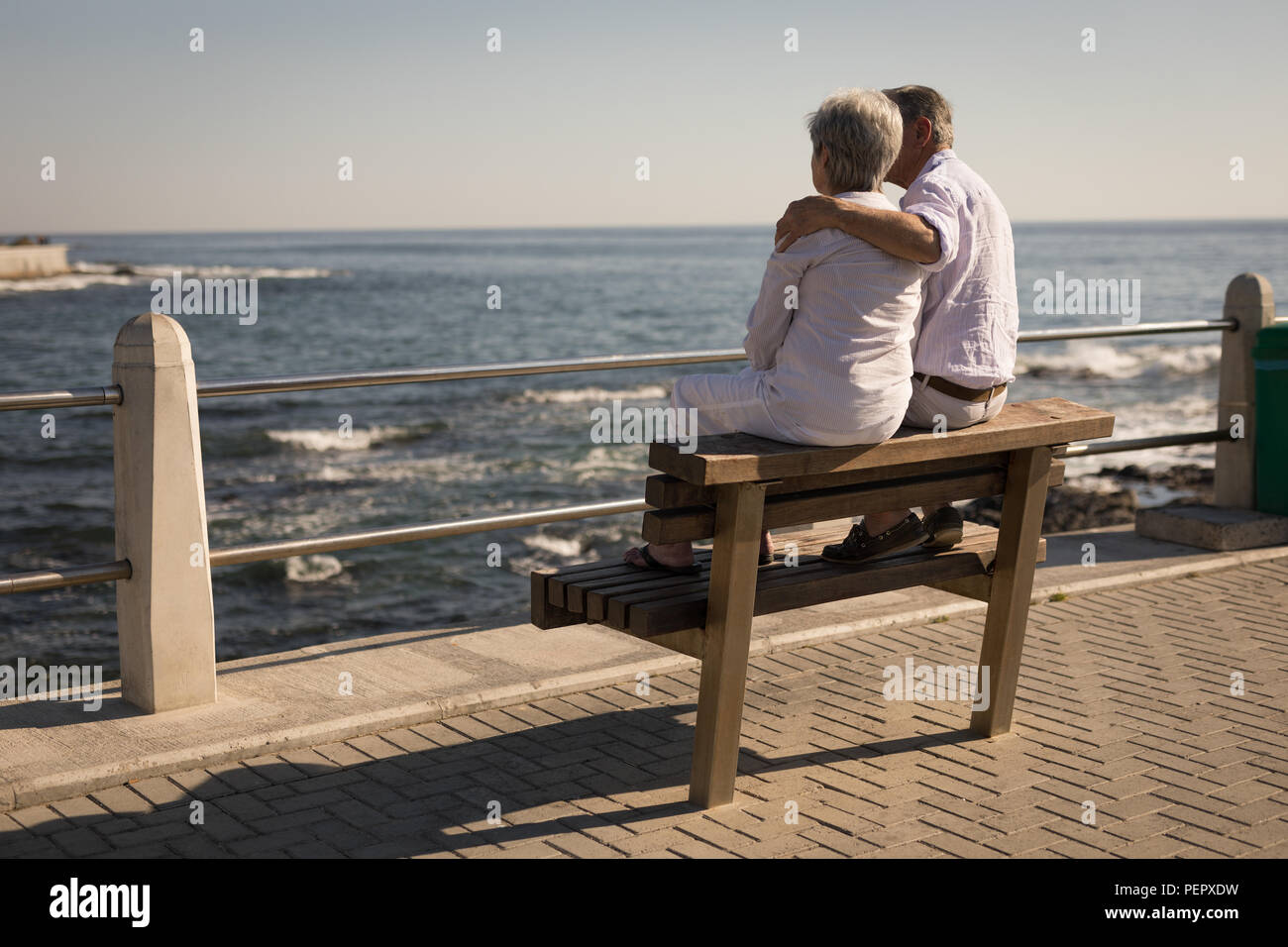 Couple assis sur un banc près de la mer Banque D'Images