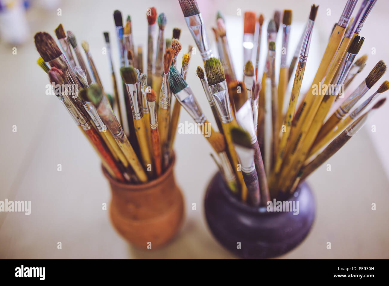 Un tas de pinceaux d'art, vases en céramique dans l'article sur la table dans l'art studio. Banque D'Images Un tas de pinceaux d'art, vases en céramique dans l'article sur la table dans l'art studio. Banque D'Images