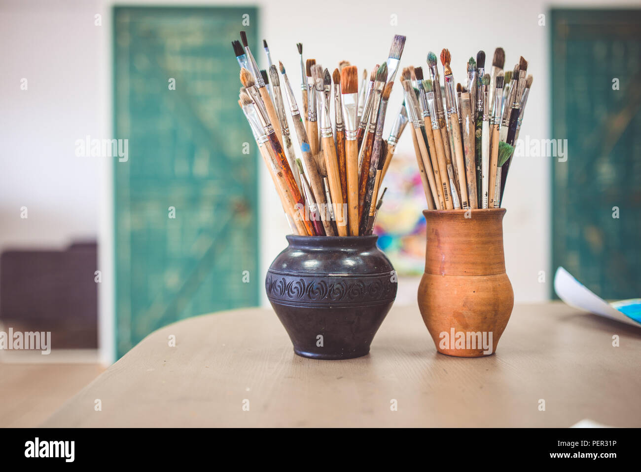 Un tas de pinceaux d'art, vases en céramique dans l'article sur la table dans l'art studio. Banque D'Images Un tas de pinceaux d'art, vases en céramique dans l'article sur la table dans l'art studio. Banque D'Images