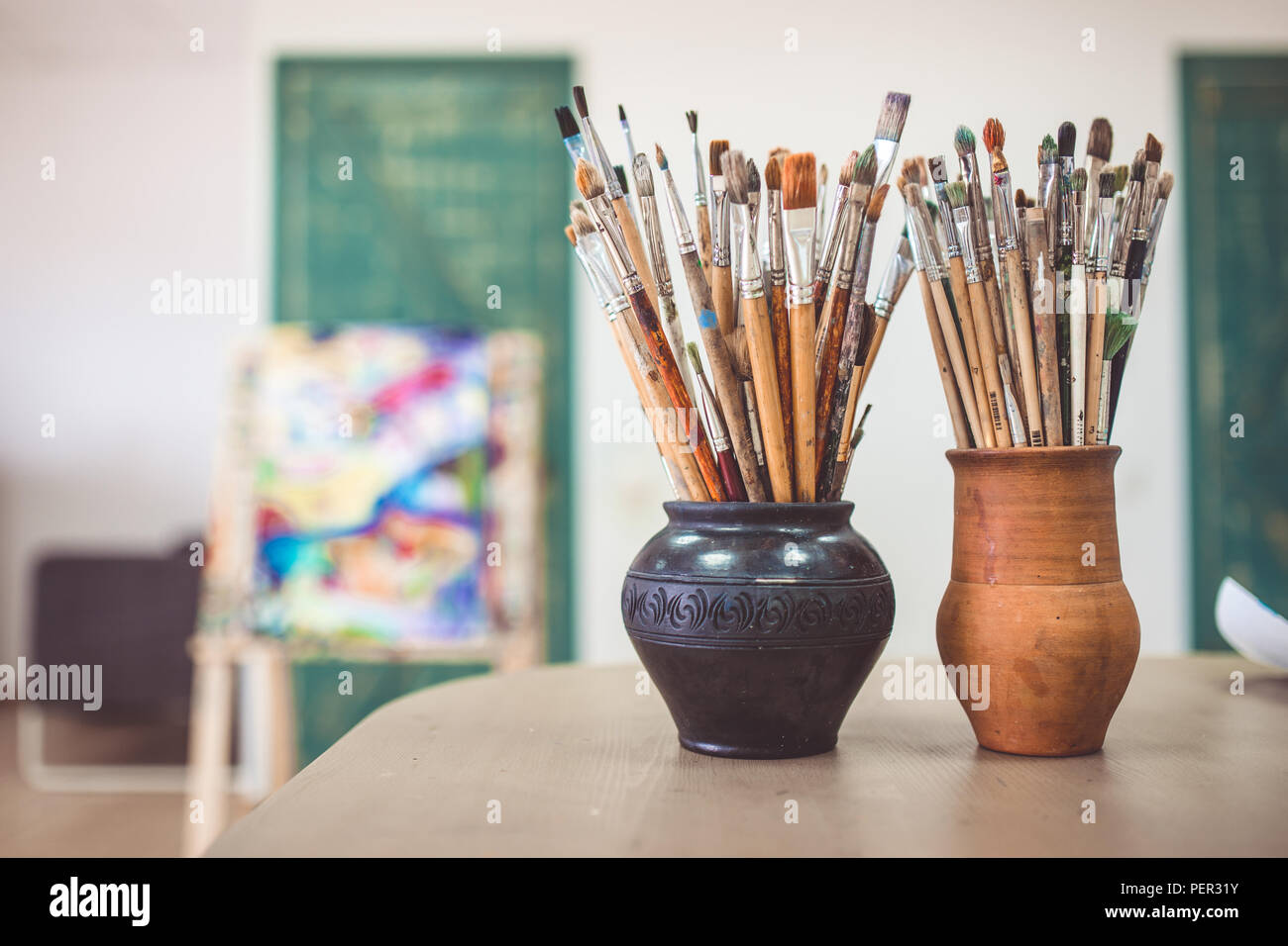 Un tas de pinceaux d'art, vases en céramique dans l'article sur la table dans l'art studio. Banque D'Images Un tas de pinceaux d'art, vases en céramique dans l'article sur la table dans l'art studio. Banque D'Images