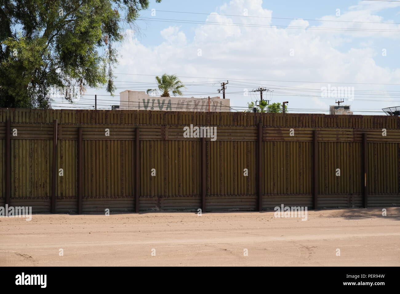 Arbres et des signes ('Viva Mexico") sur la partie mexicaine de la clôture frontalière vu depuis les États-Unis, à l'est de Calexico, en Californie, aux États-Unis. Banque D'Images