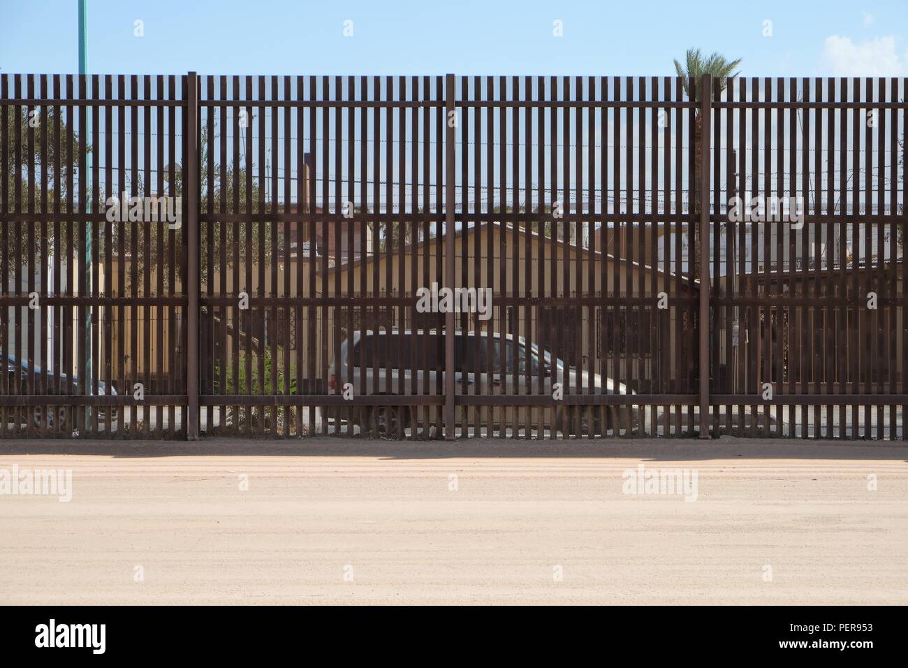 Vue d'une maison et voiture à Mexicali, Mexique, de Calexico, en Californie, États-Unis, à travers les grilles sur la frontière séparant les deux pays. Banque D'Images
