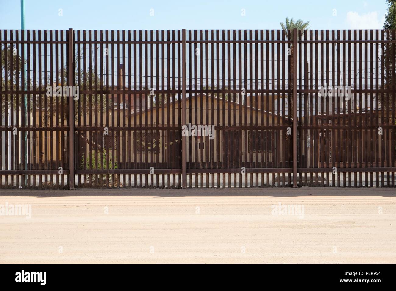 Vue d'une maison à Mexicali, au Mexique, de l'Est de Calexico, en Californie, États-Unis, à travers les grilles sur la frontière séparant les deux pays. Banque D'Images