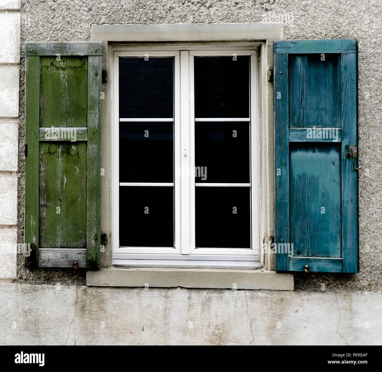 Fenêtre unique avec de vieux volets en bois bleu et vert Banque D'Images