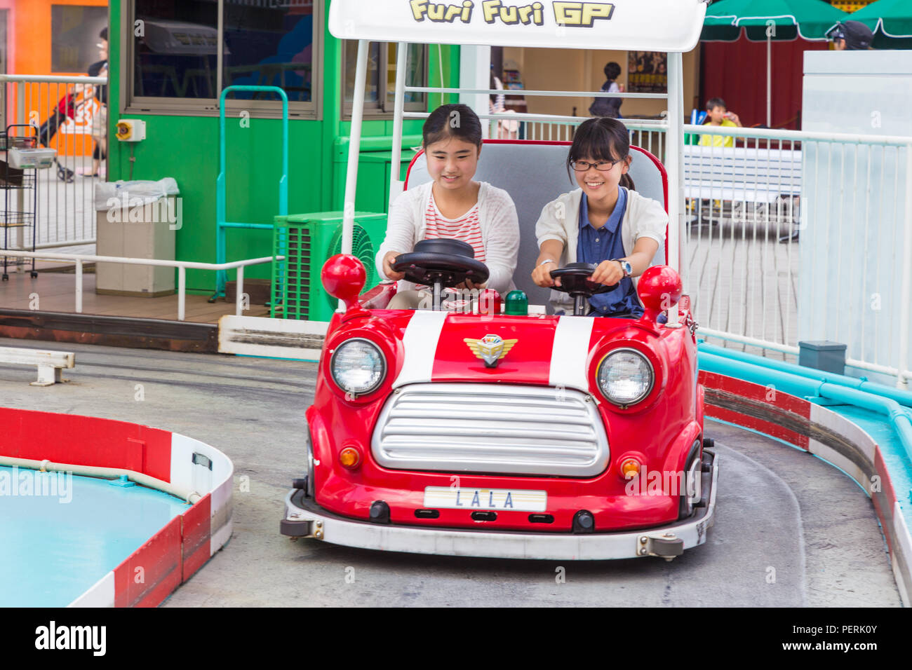 TOKYO, JAPON - 19 juillet 2016 - Deux heureux filles japonaises sur une Furi Furi GP auto au Tokyo Dome City Amusement Park à Tokyo, Japon le 19 juillet 2016 Banque D'Images
