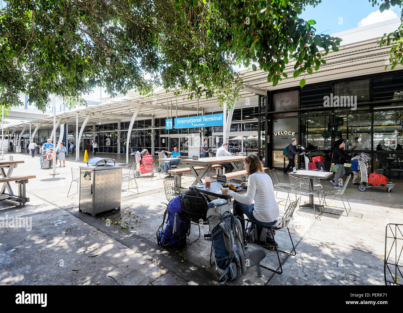 Les gens assis à un café à l'extérieur de l'aéroport de Sydney International Terminal T1, New South Wales, NSW, Australie Banque D'Images