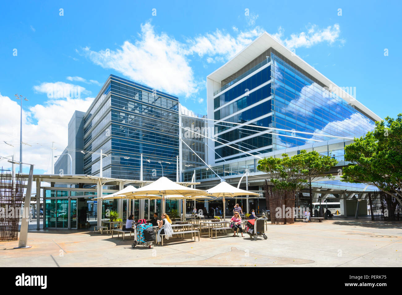 Des parasols et des gens assis à des tables à l'extérieur de l'Aéroport International Kingsford-Smith Sydney, New South Wales, NSW, Australie Banque D'Images