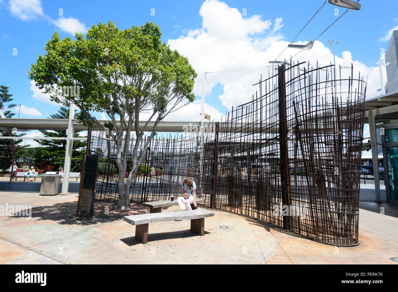 Jeune femme assise en face d'œuvres à l'extérieur de l'Aéroport International Kingsford-Smith Sydney, New South Wales, NSW, Australie Banque D'Images