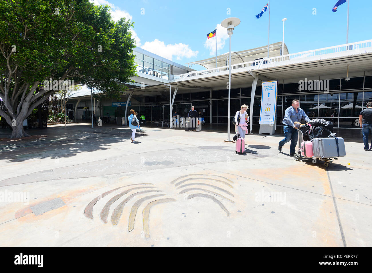 Les passagers poussant leur assurance à l'extérieur de l'Aéroport International de Sydney Kingsford-Smith, New South Wales, NSW, Australie Banque D'Images