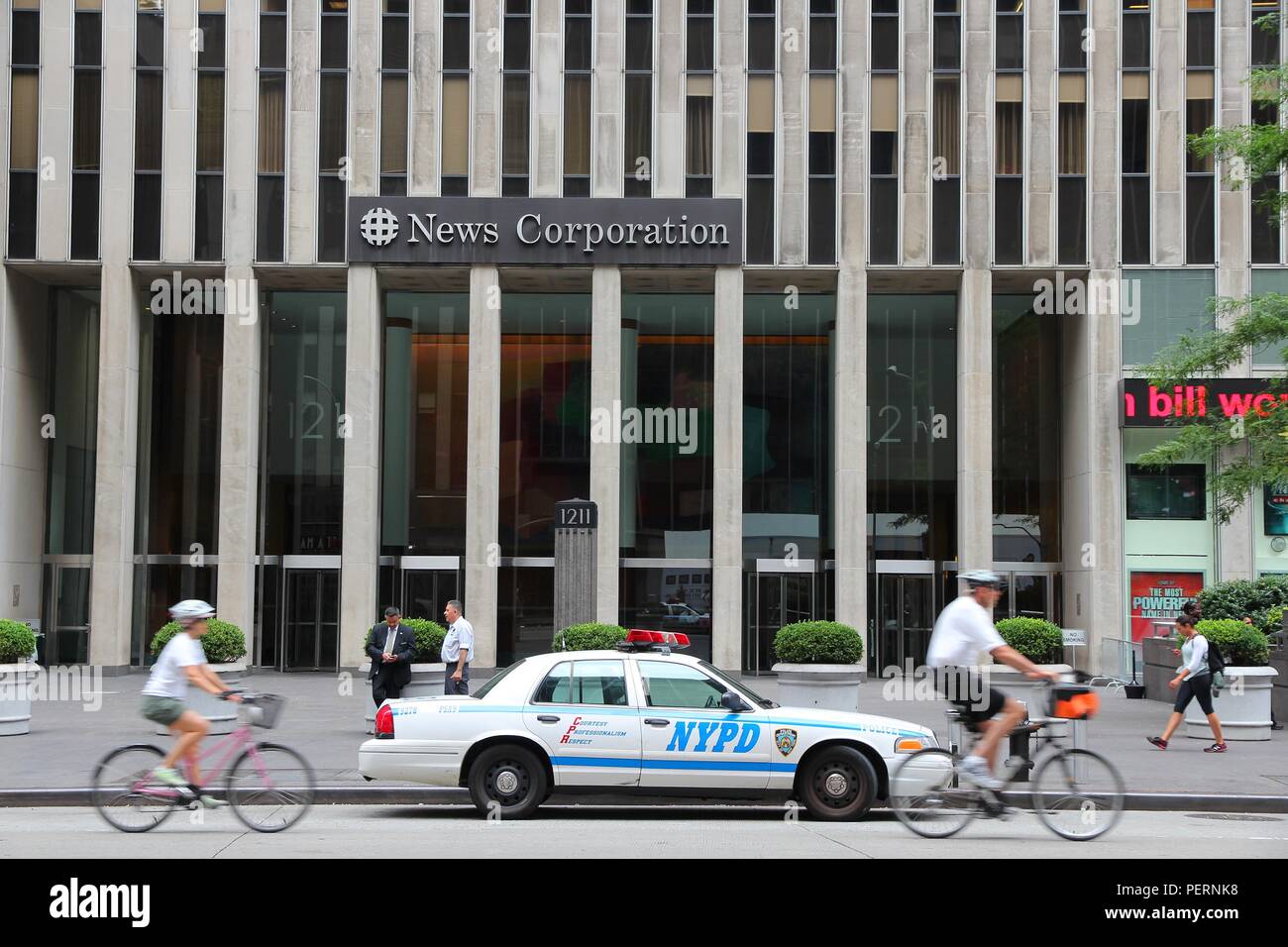 NEW YORK - 4 juillet : cyclistes roulent passé News Corporation à la 6e Avenue, le 4 juillet 2013 à New York. Célèbre News Corporation a été divisé en une News Corp Banque D'Images