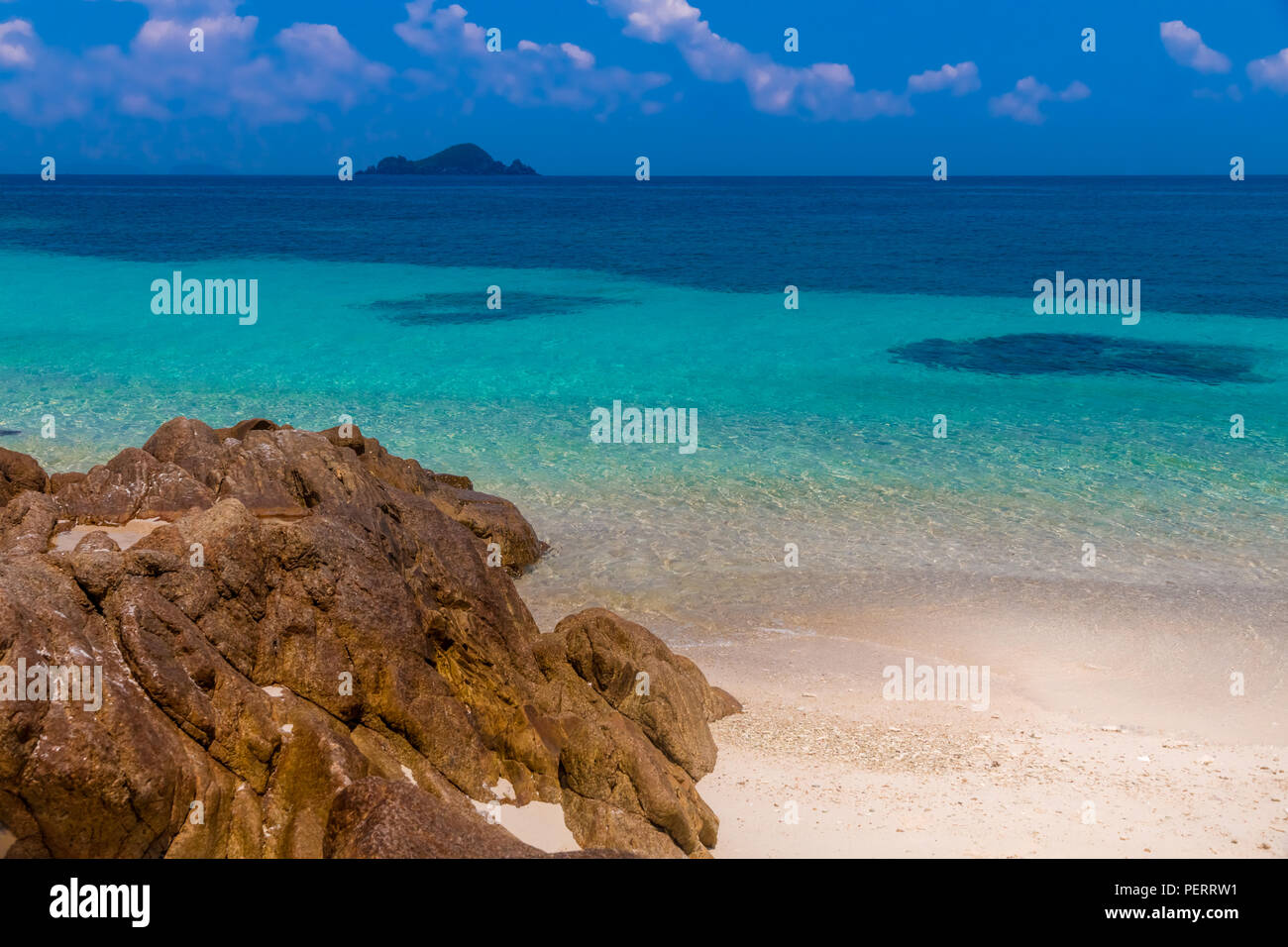 Beau paysage de la mer bleu turquoise, le sable blanc poudreux et la roche tendre la main à l'eau claire peu profonde en face de Rawa scintillant... Banque D'Images