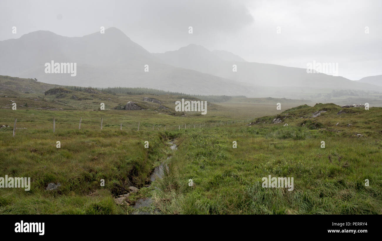 Des nuages de pluie survolez les montagnes Macgillycuddy Reeks du comté de Kerry en Irlande. Banque D'Images