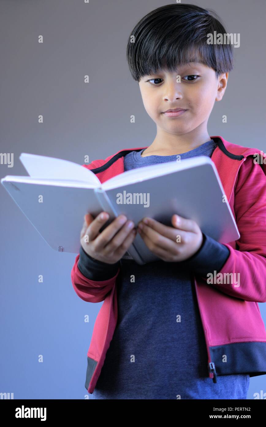 Portrait de jeune enfant livre de lecture. L'étude de livre pour enfants souriants. Banque D'Images