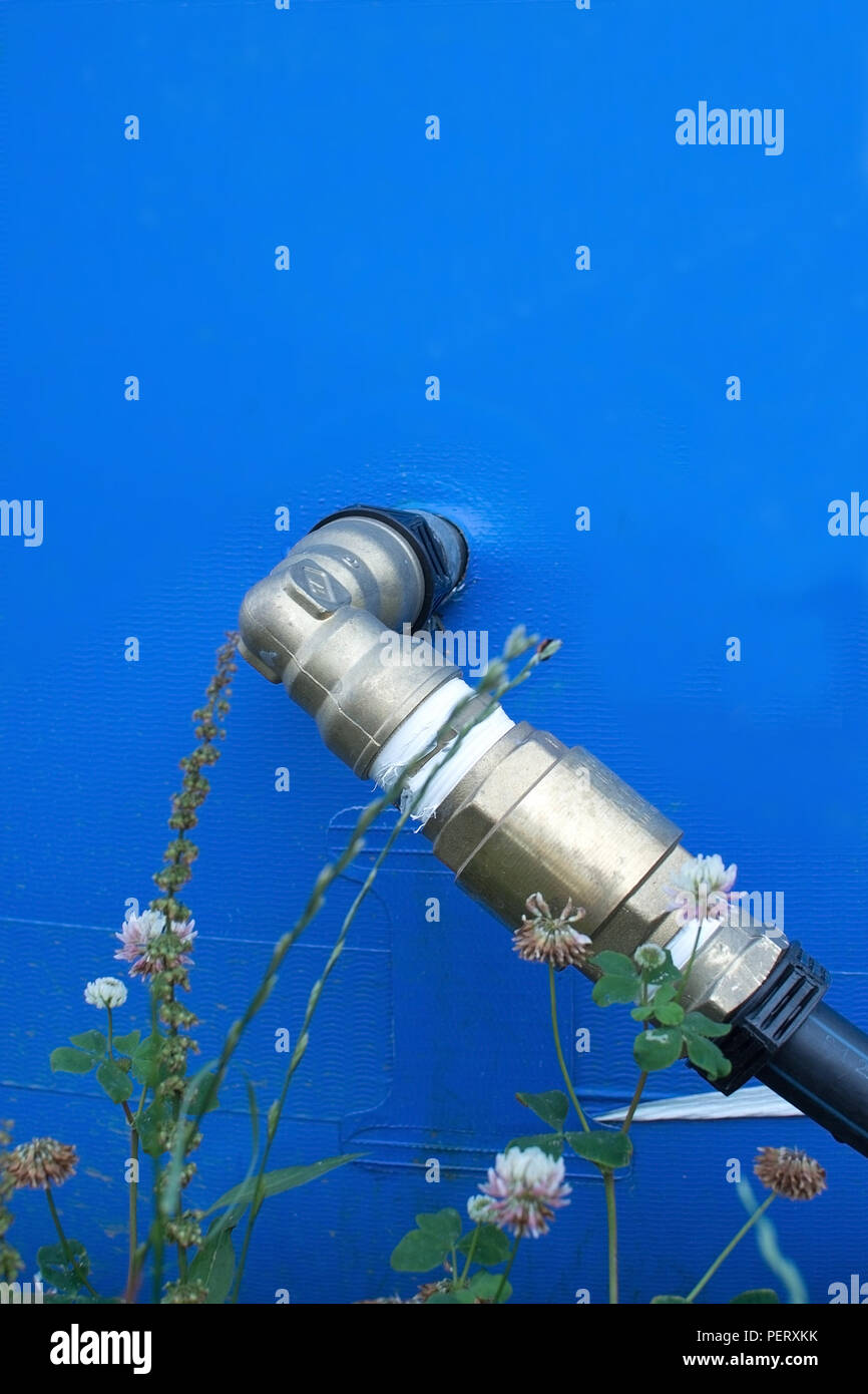 Metal'eau plomberie à connecteur en plastique bleu piscine extérieur avec pelouse et fleurs Banque D'Images