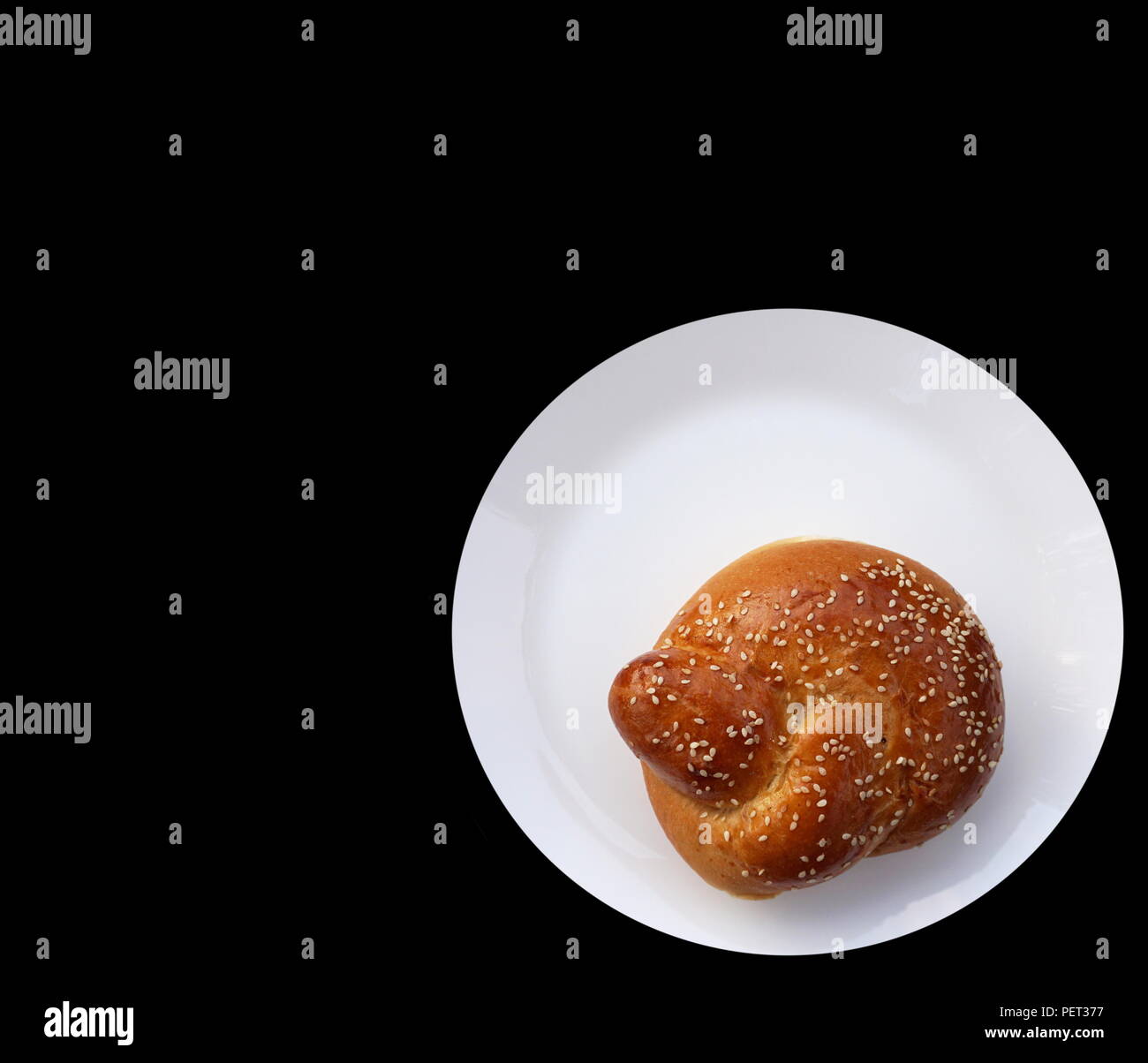 Mini challah sur plaque blanche avec fond noir Banque D'Images