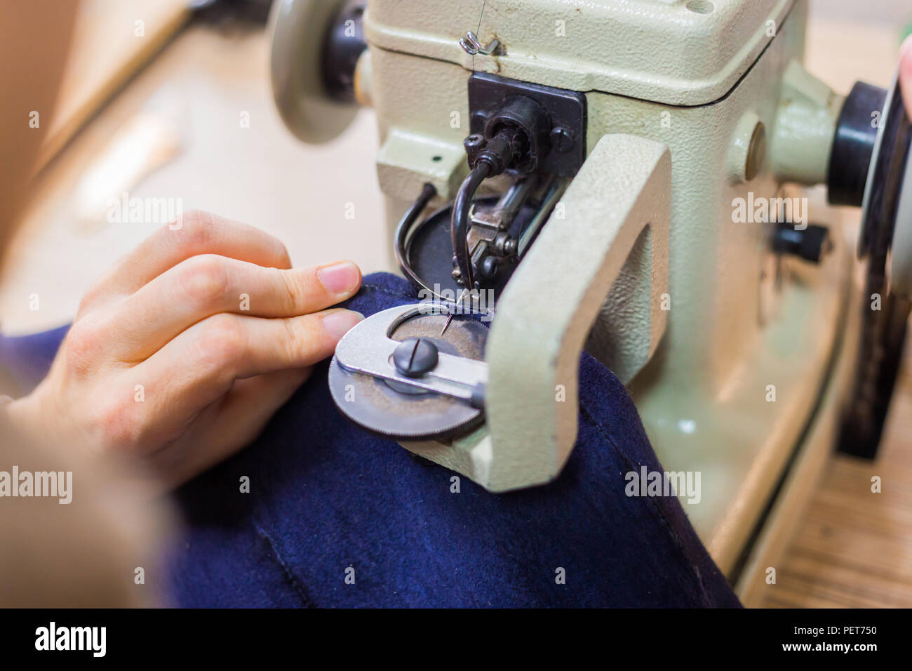 Professionnel hommes skinner, fourreur à l'aide de la machine à coudre spéciale pour coudre la peau de fourrure à l'atelier, atelier. La mode et le travail du cuir concept Banque D'Images