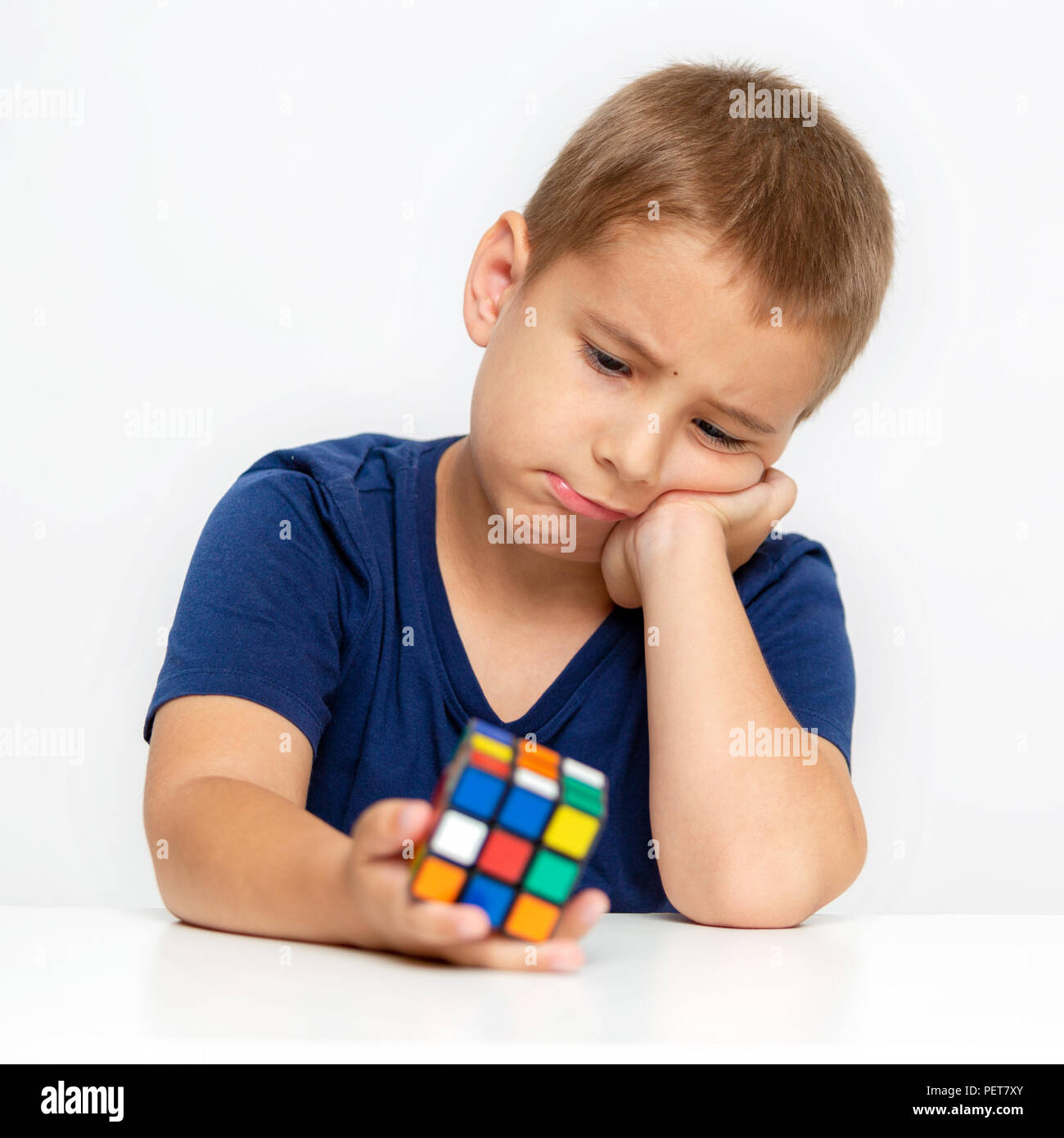 Portrait d'un enfant fatigué triste. Le garçon ne peut pas résoudre le problème. Cube Banque D'Images