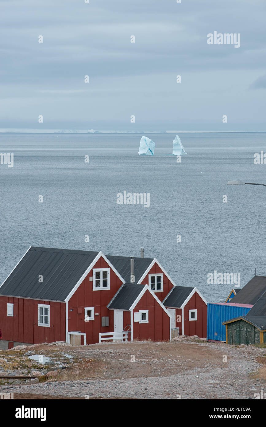 Maisons rouges surplombant la mer du Groenland avec des icebergs en automne, Ittoqqortoormiit, municipalité de Sermersooq, Groenland oriental, Royaume du Danemark Banque D'Images