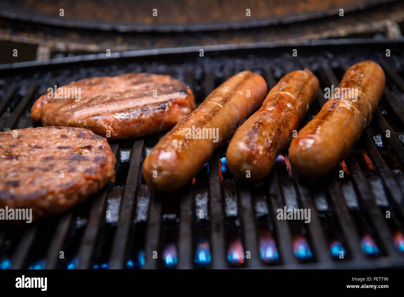 Saucisses de porc et des hamburgers grillés sur un barbecue, de près de l'Grill, la viande et le feu Banque D'Images