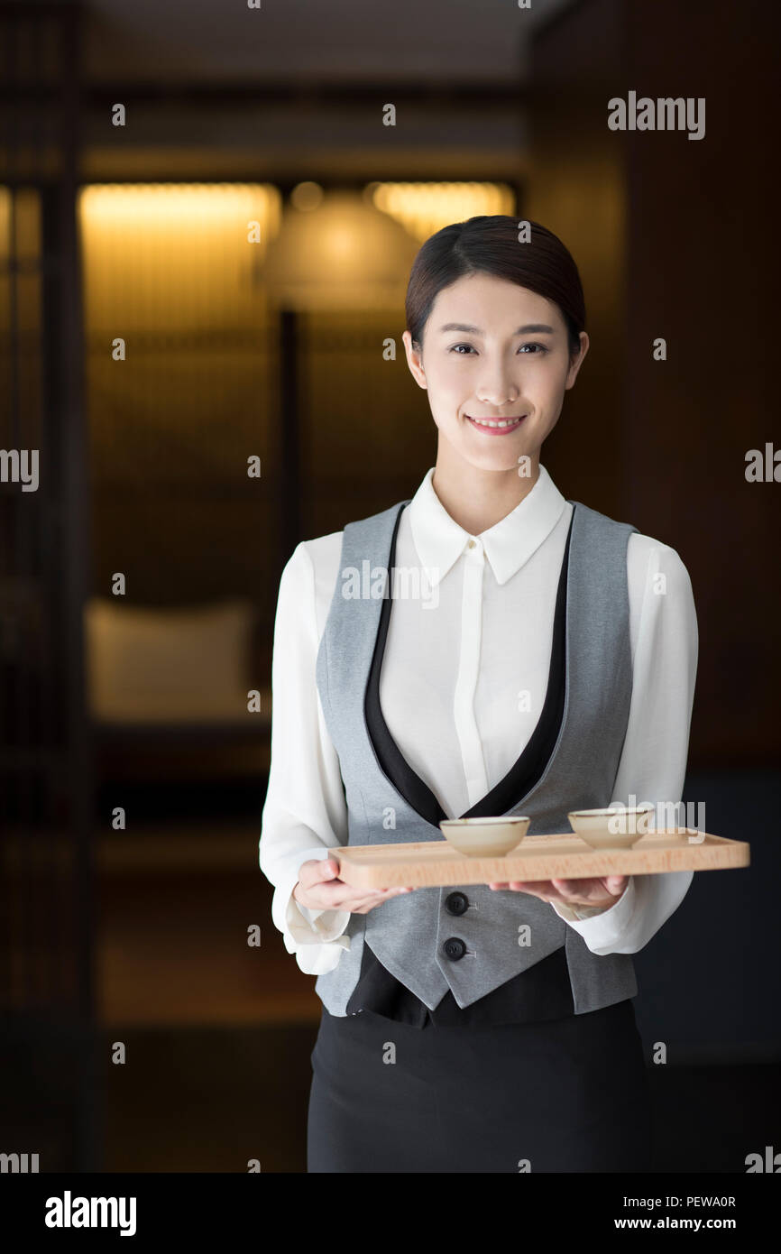 L'élégance waitress holding deux tasses de thé Banque D'Images