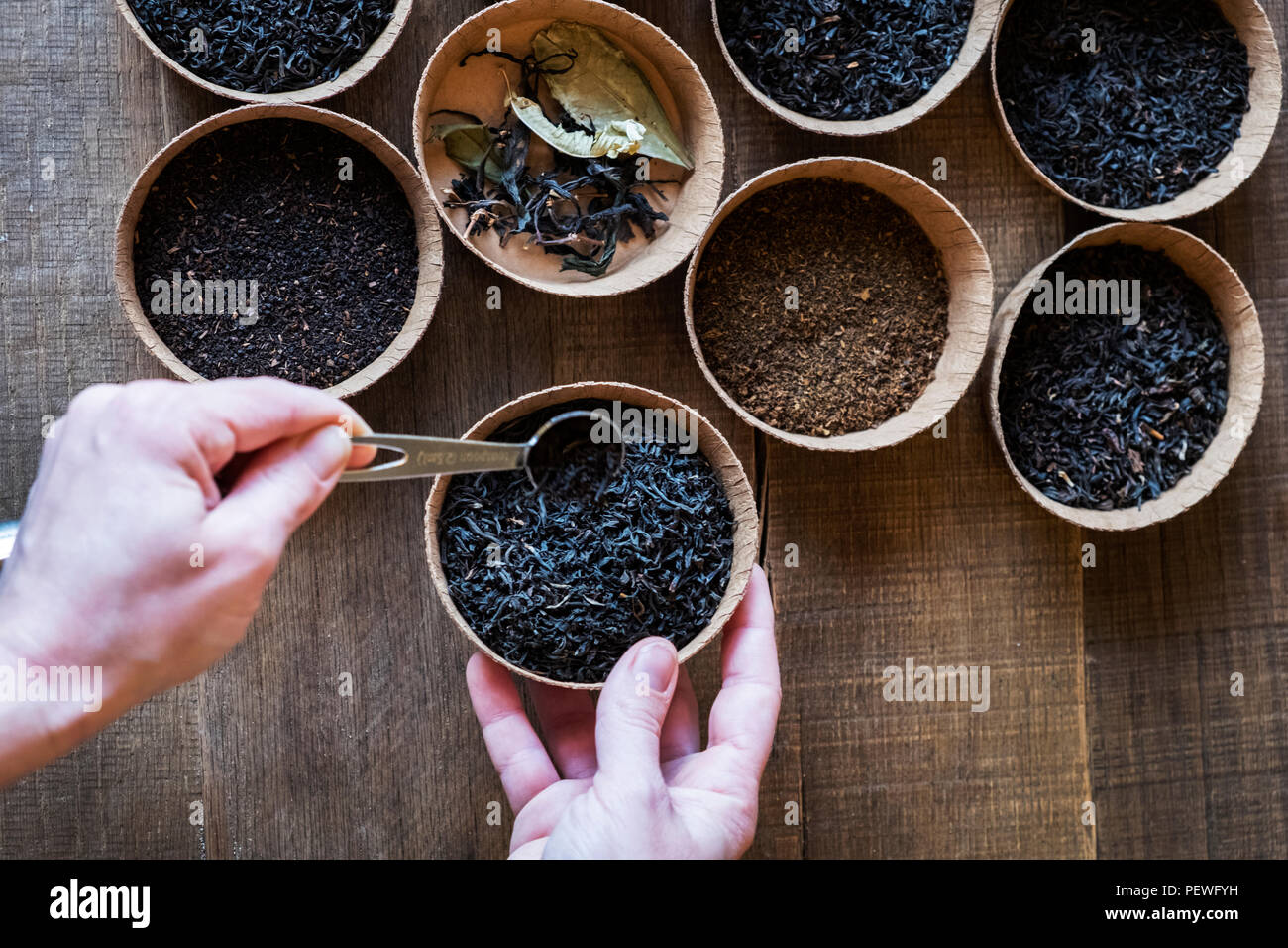 High angle close up d'une sélection de thés en feuilles dans de petits bols en bois. Banque D'Images