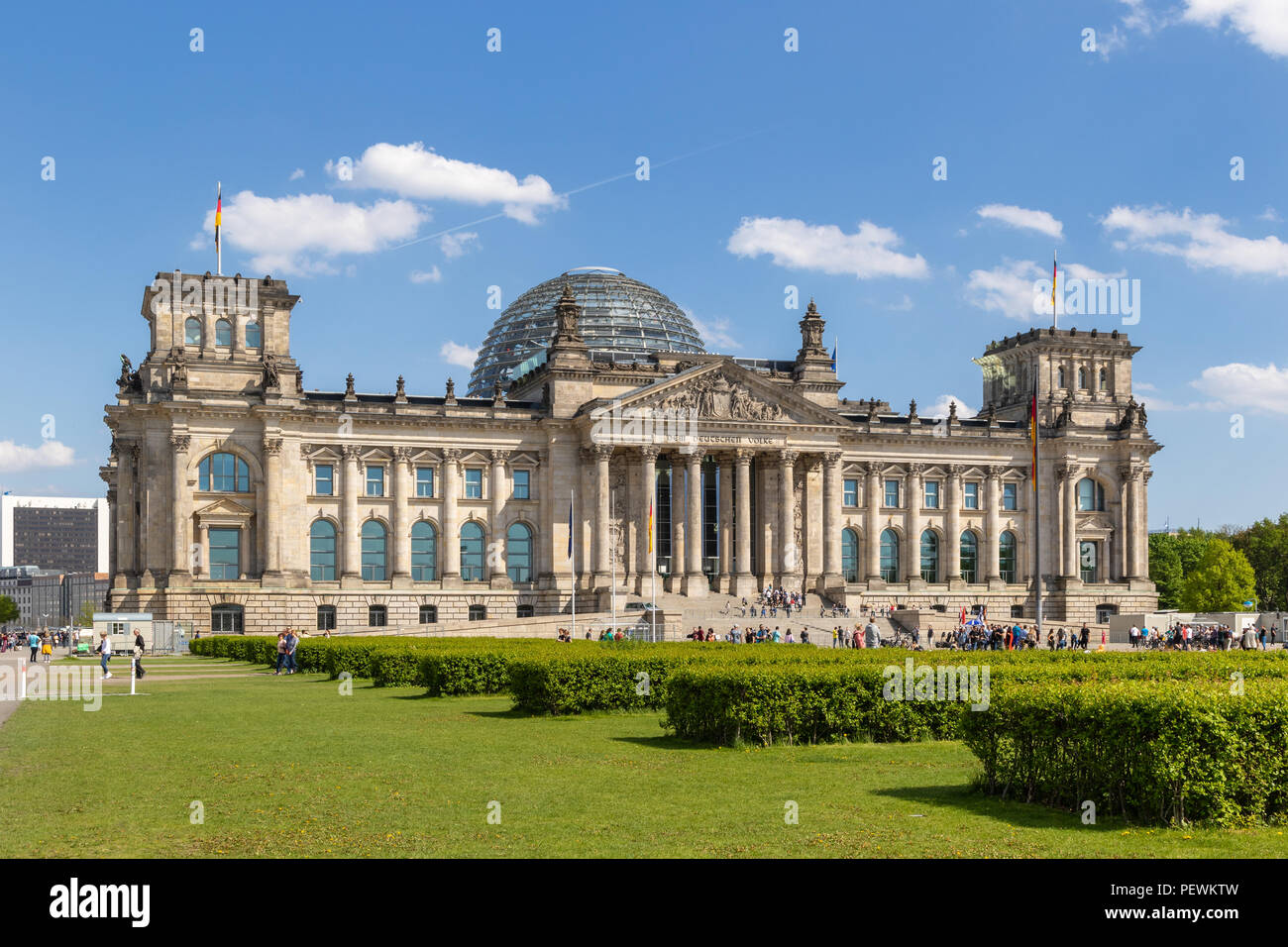 BERLIN, ALLEMAGNE - 28 avril, 2018 : Les gens de vous détendre sur l'herbe, devant le Reichstag, siège du Parlement allemand (Deutscher Bundestag). Banque D'Images