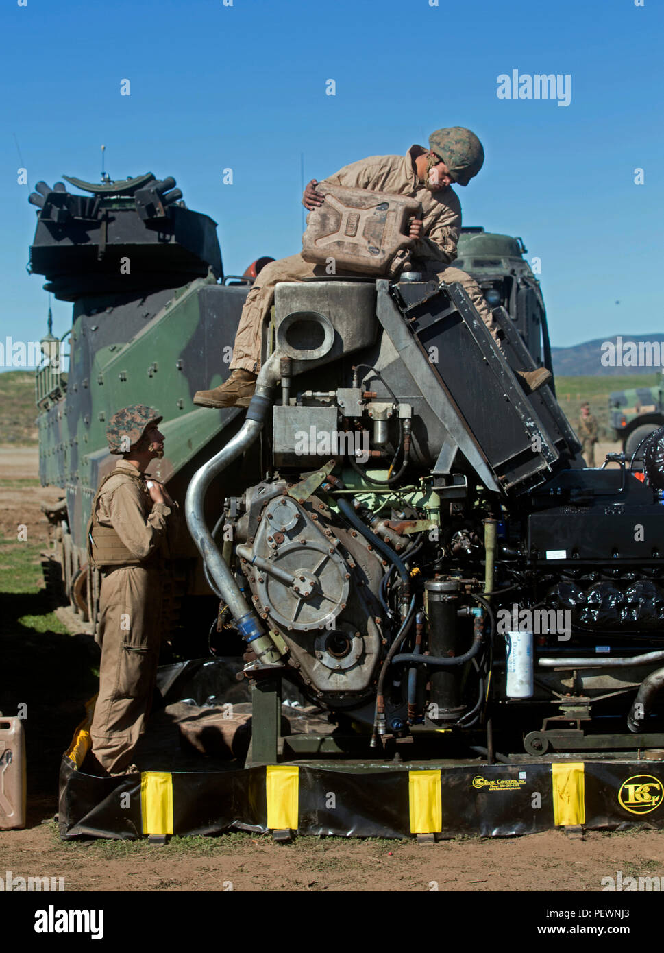 MARINE CORPS BASE CAMP PENDLETON, en Californie - PFC. Celso Romero watches Lance Cpl. Salgado Chavez comme il verse de l'eau dans un assaut véhicule amphibie moteur au Camp Pendleton, le 2 février 2016. 3e bataillon amphibie assaut fournit des fonctions de maintenance et de l'avant pour permettre la restauration immédiate des AAVs qui décomposent. Romero, de Fresno est un pilote d'AAV avec l'entreprise A., 3e AAB. Chavez, de Seattle, Washington est un homme d'équipage d'AAV avec Co. A., 3e AAB. (U.S. Marine Corps Photo par Lance Cpl. Justin E. Bowles) Banque D'Images