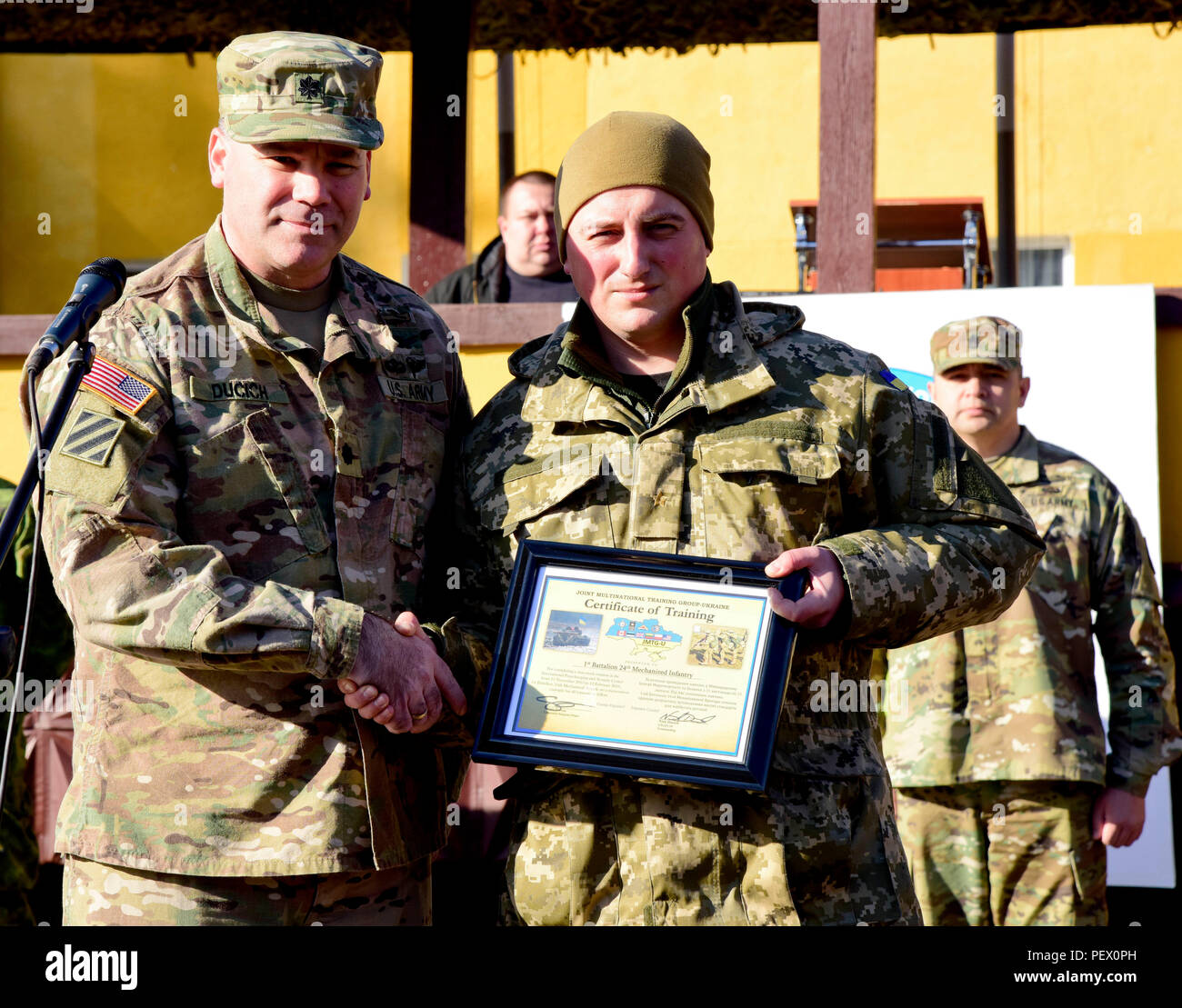Le lieutenant-colonel Nick Ducich, groupe multinational interarmées, commandant l'Ukraine présente un prix à Mykhaylovych Korenuyk Le Lieutenant-colonel Roman, 1er Bataillon, 24e Brigade mécanisée, 12 février 2016 commandant, au cours de la cérémonie de remise des diplômes de la première rotation de Fearless Guardian II au maintien de la paix et la sécurité internationale Centre près de l'Ukraine, l'viv. La deuxième phase du gardien intrépide sera composée de cinq bataillons de la formation des soldats de l'armée ukrainienne et un bataillon des forces spéciales dans le cadre du groupe multinational interarmées de l'Ukraine. (Photo de Sarah Tate JMTC, Affaires publiques Banque D'Images