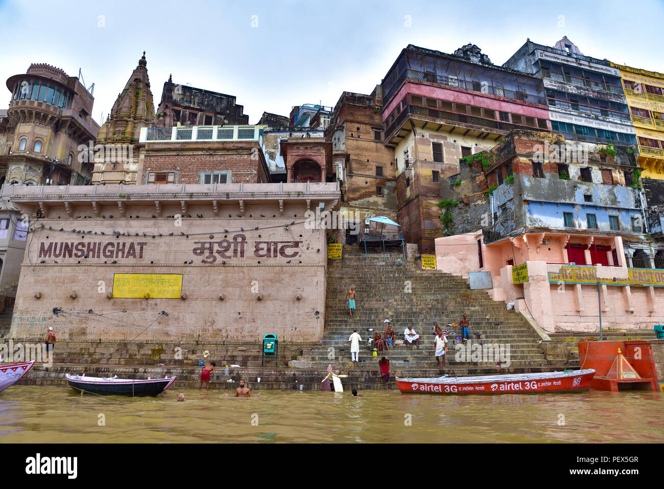 Bâtiments et ghat le long du Gange avec des personnes et des bateaux Banque D'Images