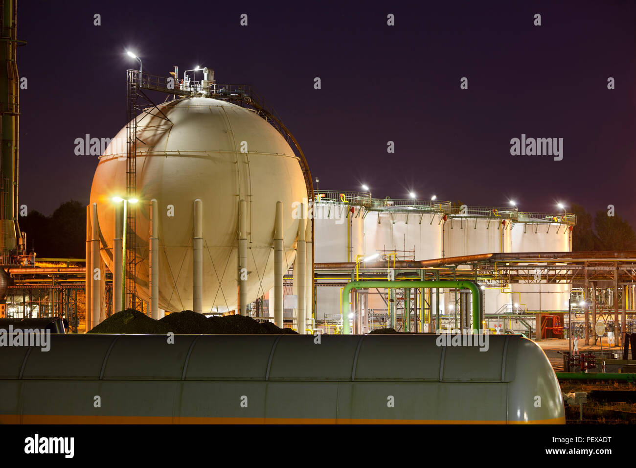 L'huile et les réservoirs à gaz liquide dans une usine chimique dans la nuit. Banque D'Images