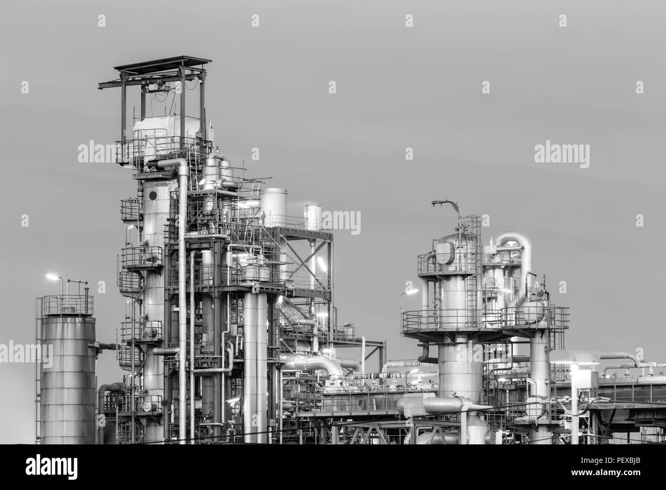 Tours de distillation des raffineries de pétrole dans la nuit en noir et blanc. Banque D'Images