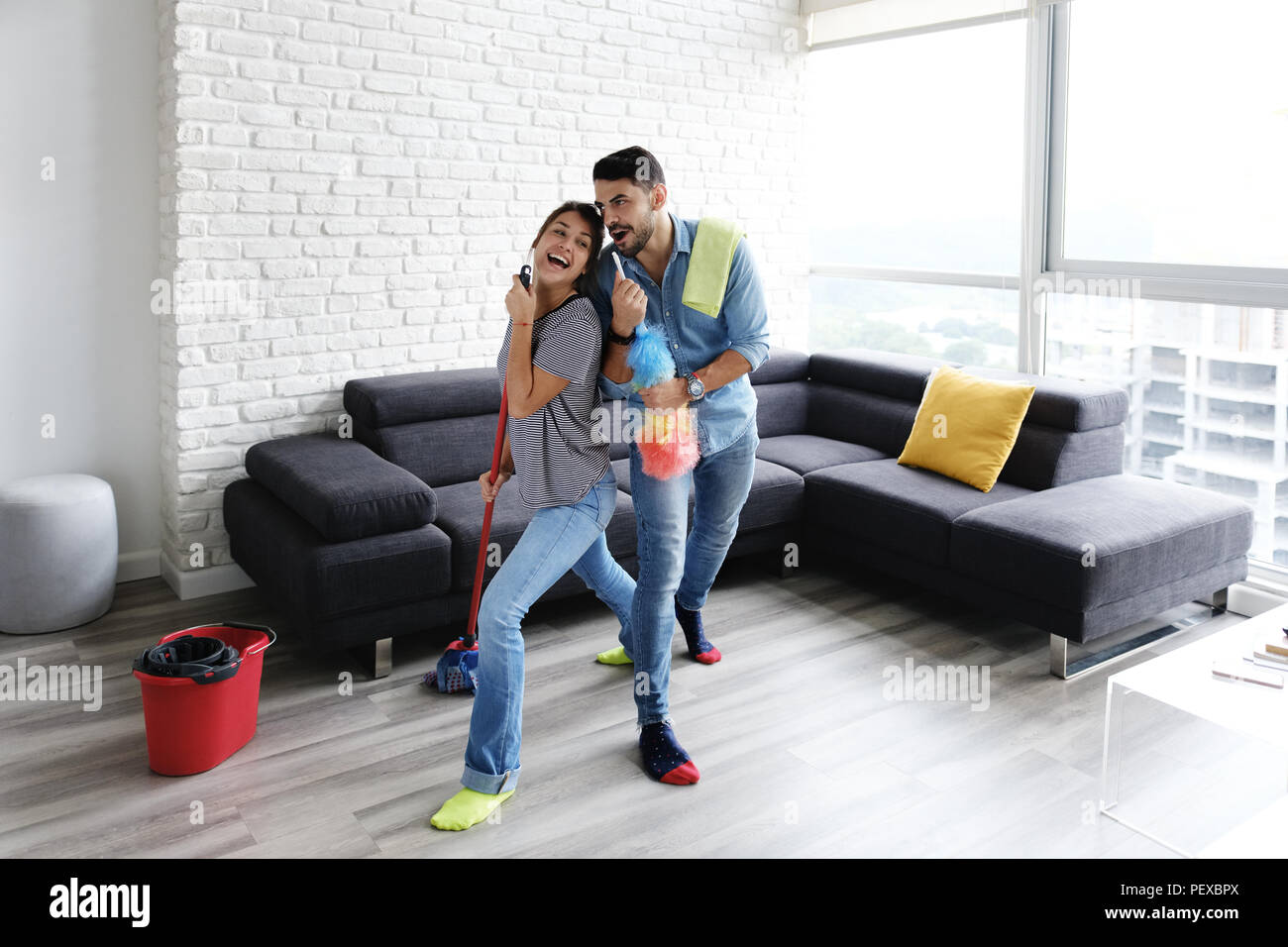 Homme et femme dansant lors du nettoyage de la maison Banque D'Images