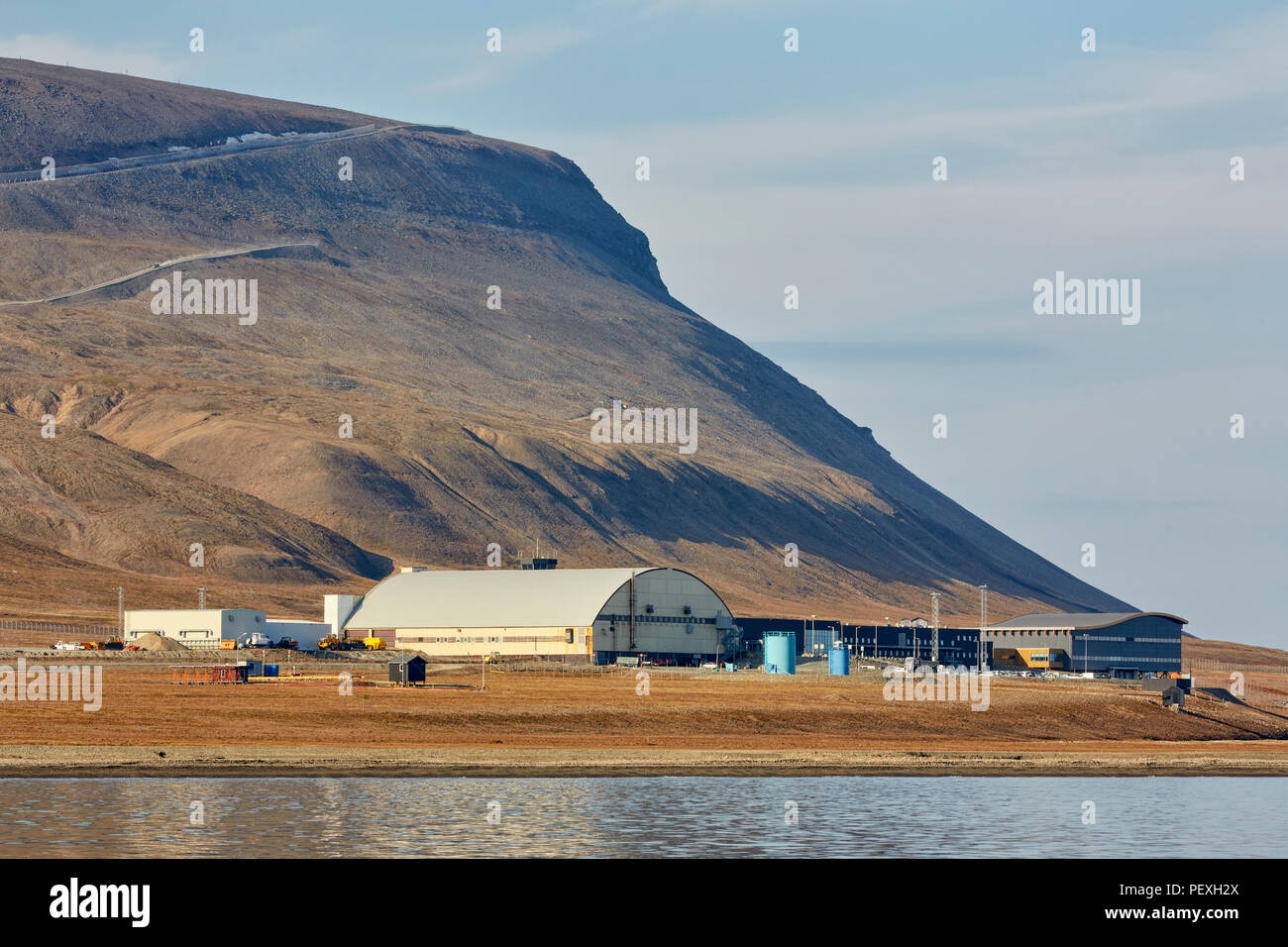 L'aéroport de Longyearbyen avec montagne aride derrière elle et un fjord dans l'avant-plan Banque D'Images